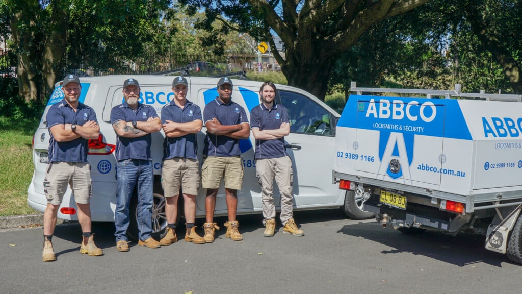 The Abbco team standing in front of the branded cars